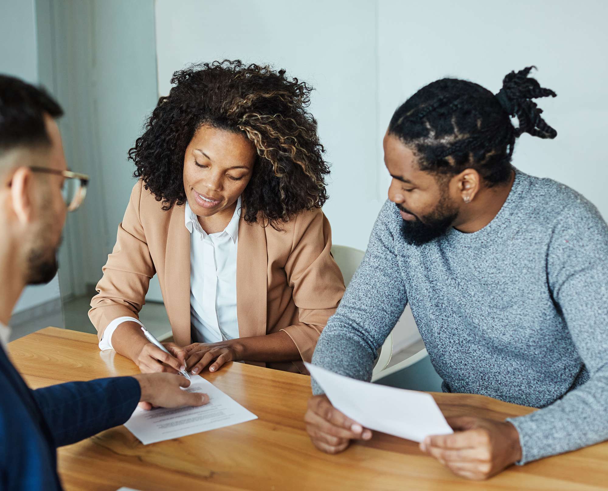 A picture of a couple signing insurance paperwork - being properly licensed, insured and bonded is an important part of starting a cleaning business in the state of Texas